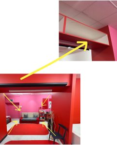 A collage of two images. The bottom left side is an image of a room. The walls are bright red and bright pink. The bright pink wall has yellow arrows indicating towards it. The right top corner of the image showcases a shelf where a projector will be put.